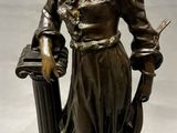 statue en bronze représentant une femme tenant un panier et un couteau
