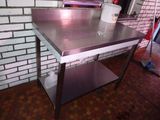 une table en acier inoxydable sur laquelle est posé un seau