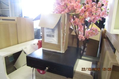 une table noire sur laquelle se trouve une boîte et une fleur rose dans un vase
