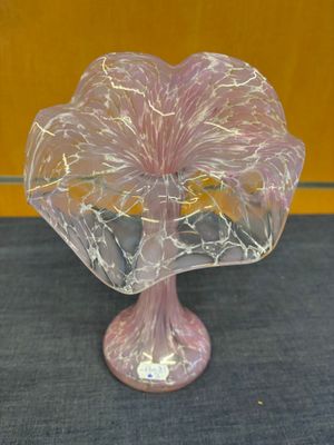 un vase en verre orné d'une fleur rose, posé sur une table