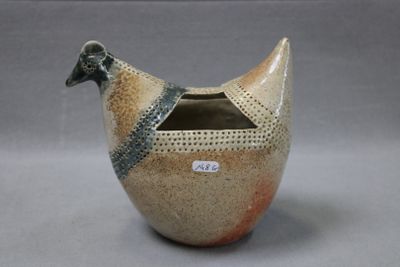 un vase en forme d'oiseau avec un couvercle, posé sur une table