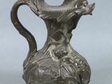 a silver vase with a fish on it