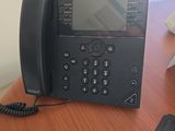 un téléphone noir posé sur un bureau en bois, à côté d'un téléphone portable