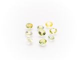 a group of yellow and green gems on a white surface