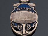 a silver medal with a boat on it on a black surface