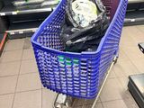 a blue shopping cart with a bag of garbage in it