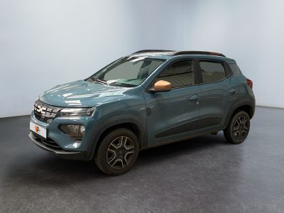 La voiture bleue est garée dans une grande pièce au sol noir.