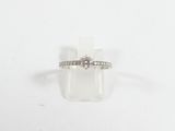 une photo d'une bague en diamant posée sur un bloc transparent