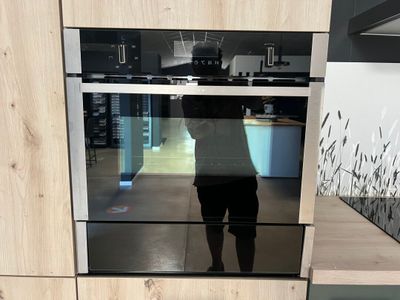 une personne debout devant un four dans une cuisine