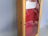 a small wooden cabinet with a mirror on top of it