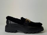 a black loafer with a gold buckle on the top of it