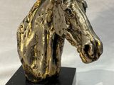 statue of a golden horse head on a black base