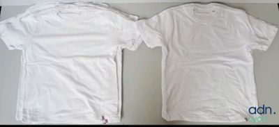 two white t - shirts sitting next to each other on a table
