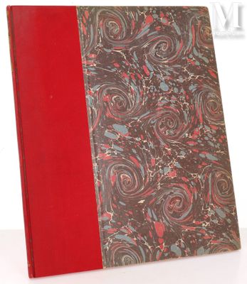 an old book with a red cover sitting on top of a white table