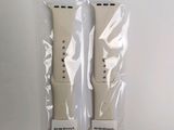 two apple watch bands wrapped in plastic on a white surface