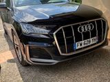 Le SUV Audi noir est garé devant un immeuble.