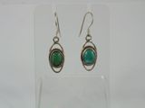 a pair of earrings with a green stone in the middle