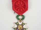 gros plan d'une médaille sur une surface blanche avec un ruban rouge