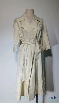 une robe posée sur un présentoir à mannequin, avec un mur blanc en arrière-plan