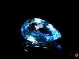 a close up of a blue diamond on a black surface