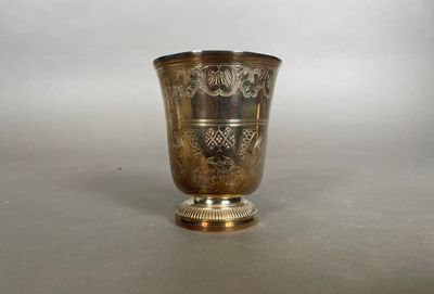 un vase en argent posé sur une table, sur fond blanc