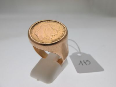 une bague sur laquelle est posée une pièce et à laquelle est attachée une étiquette de prix