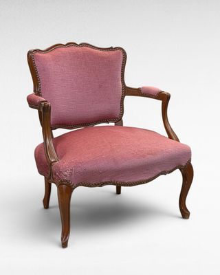 a pink chair with a wooden frame and a pink upholstered seat