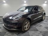 the porsche macan is parked in the garage on a checkered floor