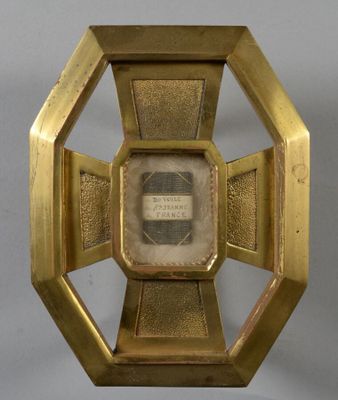 une image représentant une horloge dorée avec une illustration au centre