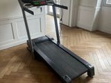the tread machine is sitting on the wooden floor in the room