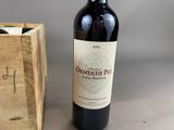 a bottle of wine that is sitting next to a wooden box