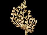 a gold plated brooch with leaves and leaves on it