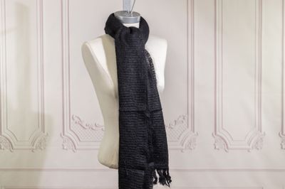 a black scarf hanging on a mannequin in a room