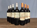 several bottles of wine are lined up on a wooden table