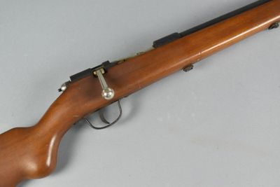 an old rifle with a wooden handle on a white surface