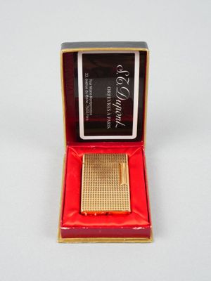 une photo d'une petite montre plaquée or dans un coffret rouge