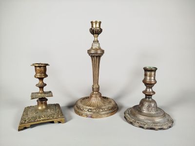 trois bougeoirs en laiton vieilli sur fond blanc