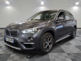 the bmw x1 is parked in a showroom with a checkered floor