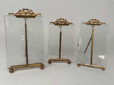 three pieces of glass with gold decorations on them sitting on a white surface