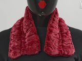 une tête de mannequin coiffée d'un foulard rouge