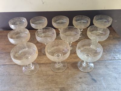a lot of empty wine glasses sitting on a wooden table