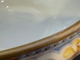 a white bowl with yellow flowers on it sitting on a table