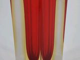 a glass vase with a red and yellow design on it