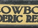 cowboy by freedom ' s remington sign on the side of a building