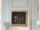 un tableau accroché au mur au-dessus de la cheminée dans un salon