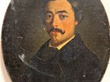 portrait of a man with a moustache in a black coat