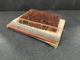 three books stacked on top of each other on a table