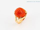 une image d'une bague en or avec une pierre rouge au centre