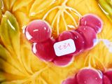 un vase jaune orné de cerises rouges, avec une étiquette de prix