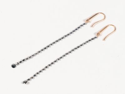 une paire de boucles d'oreilles en diamant noir et blanc sur fond blanc